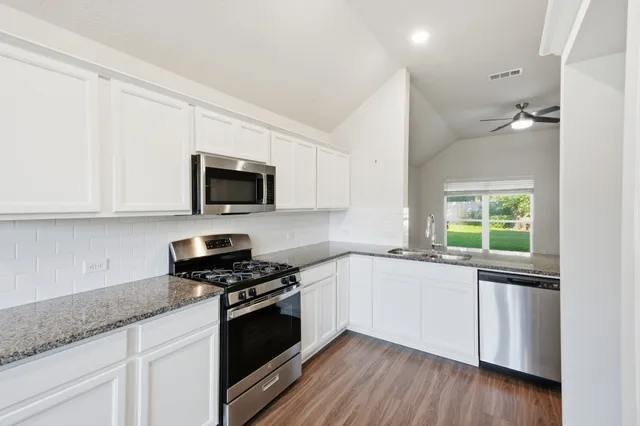 an empty room with a window and a ceiling fan