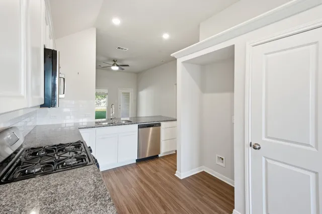 a bathroom with a granite countertop sink a toilet and bathtub