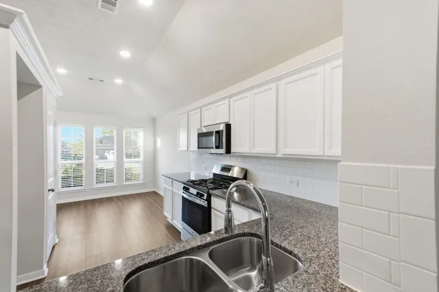 an empty room with wooden floor and ceiling fan