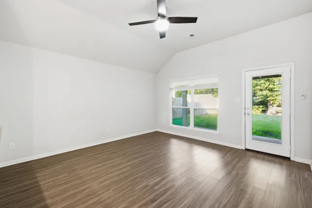 a view of a room with wooden floor and a ceiling fan