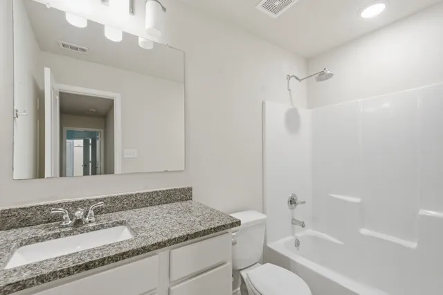 a view of a yard in front of a house with a large tree