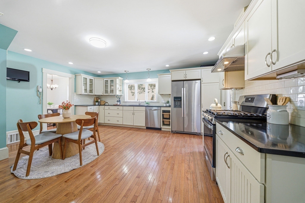 45 Marion Street Natick, MA 01760 - Photo 19 of 42 a kitchen with stainless steel appliances granite countertop a table chairs stove microwave and cabinets