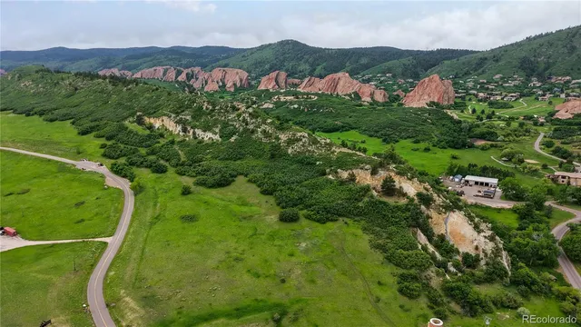 an aerial view of green landscape with trees houses and mountain view