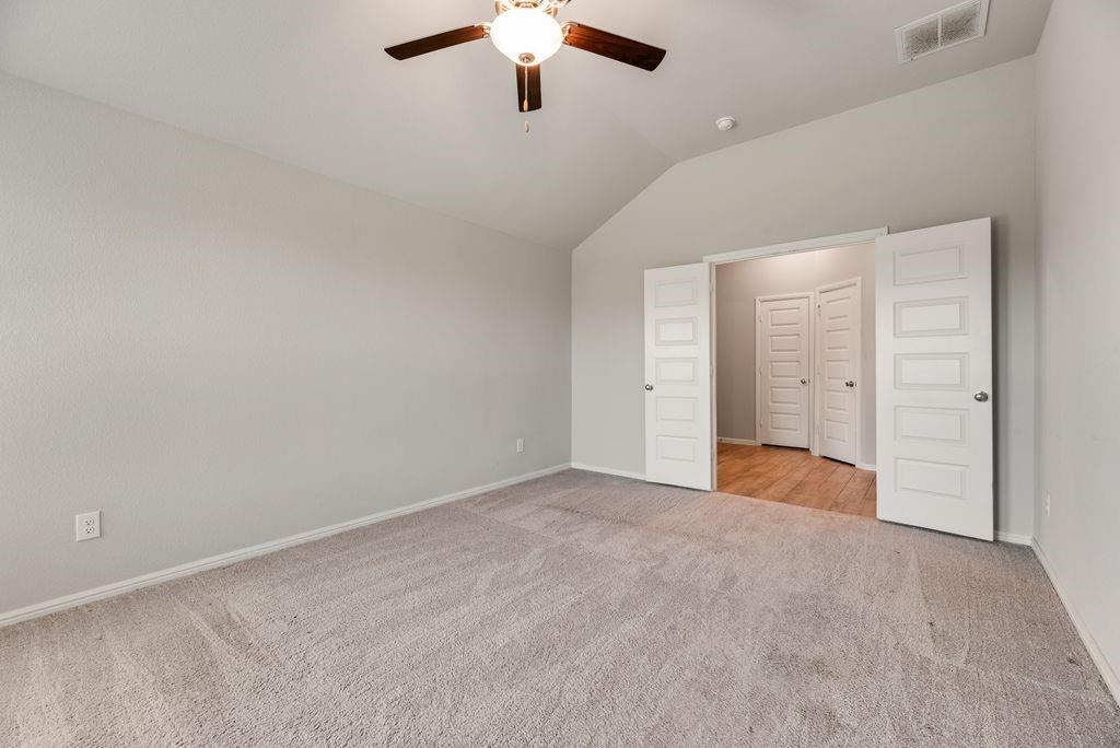 14216 Aberavon Drive Pilot Point, TX 76258 - Photo 11 of 19 Carpeted room with a vaulted ceiling and a ceiling fan with integrated lighting