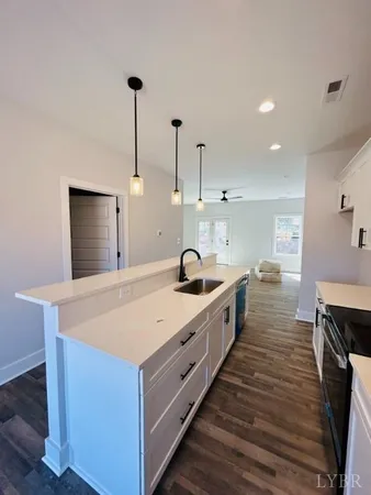 a large kitchen with kitchen island a sink dishwasher a stove and a refrigerator with wooden floor