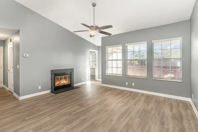 a view of empty room with wooden floor fireplace and a window