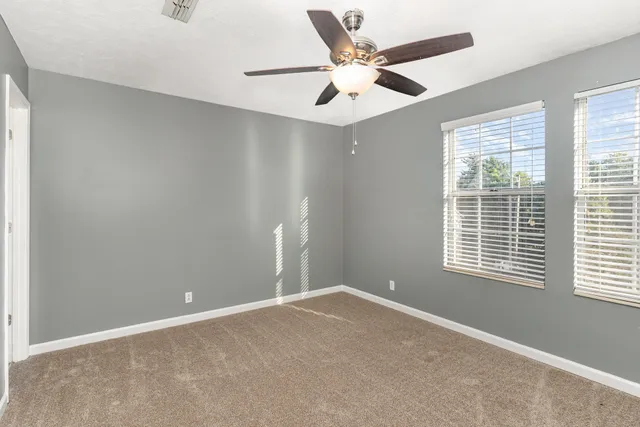 a bathroom with a granite countertop bathtub shower sink vanity mirror and toilet