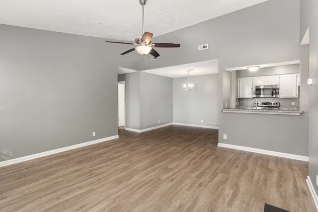 a view of a kitchen with wooden floor and a kitchen space