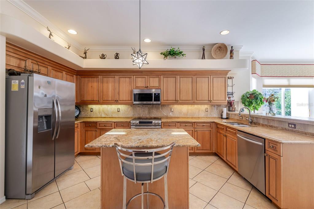 13881 Blenheim Trail Road Fort Myers, FL 33908 - Photo 15 of 82 a kitchen with stainless steel appliances granite countertop a refrigerator a sink dishwasher a stove and white cabinets with wooden floor