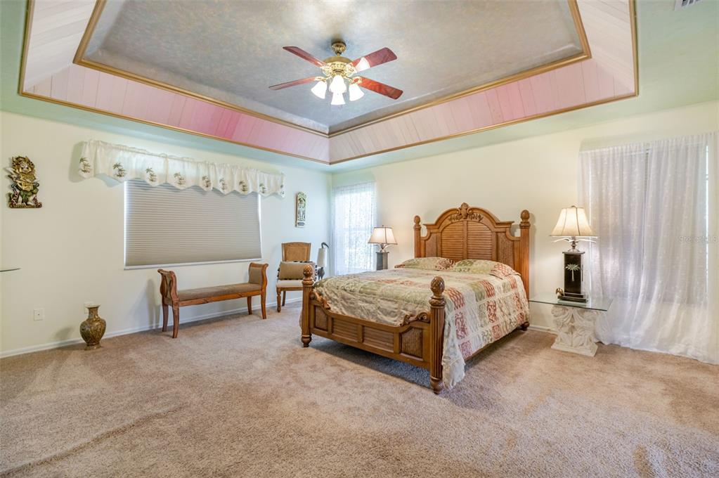 13881 Blenheim Trail Road Fort Myers, FL 33908 - Photo 41 of 82 a spacious bedroom with a bed and a chandelier