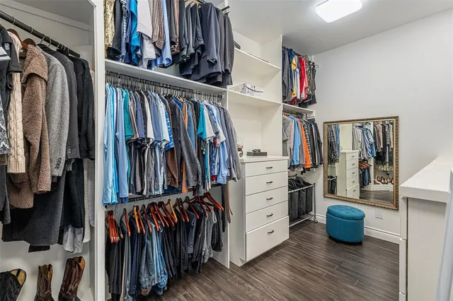 a view of walk in closet with clothes and shoes