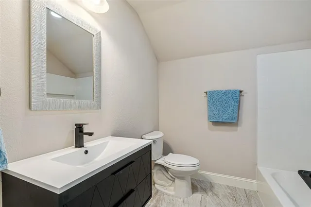 a bathroom with a sink mirror and toilet