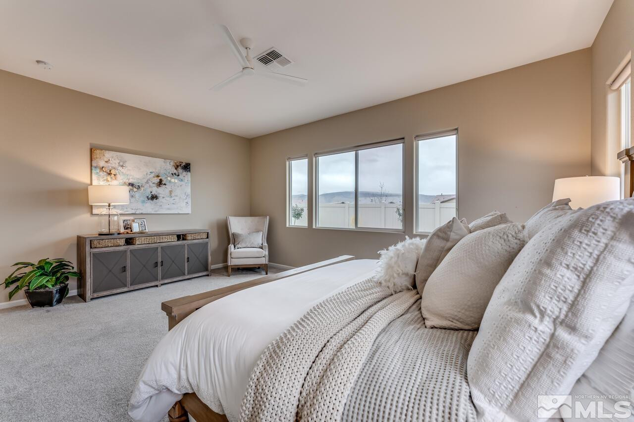 9915 Hafflinger Lane Reno, NV 89521 - Photo 23 of 40 a bedroom with a bed a large window and wall painting