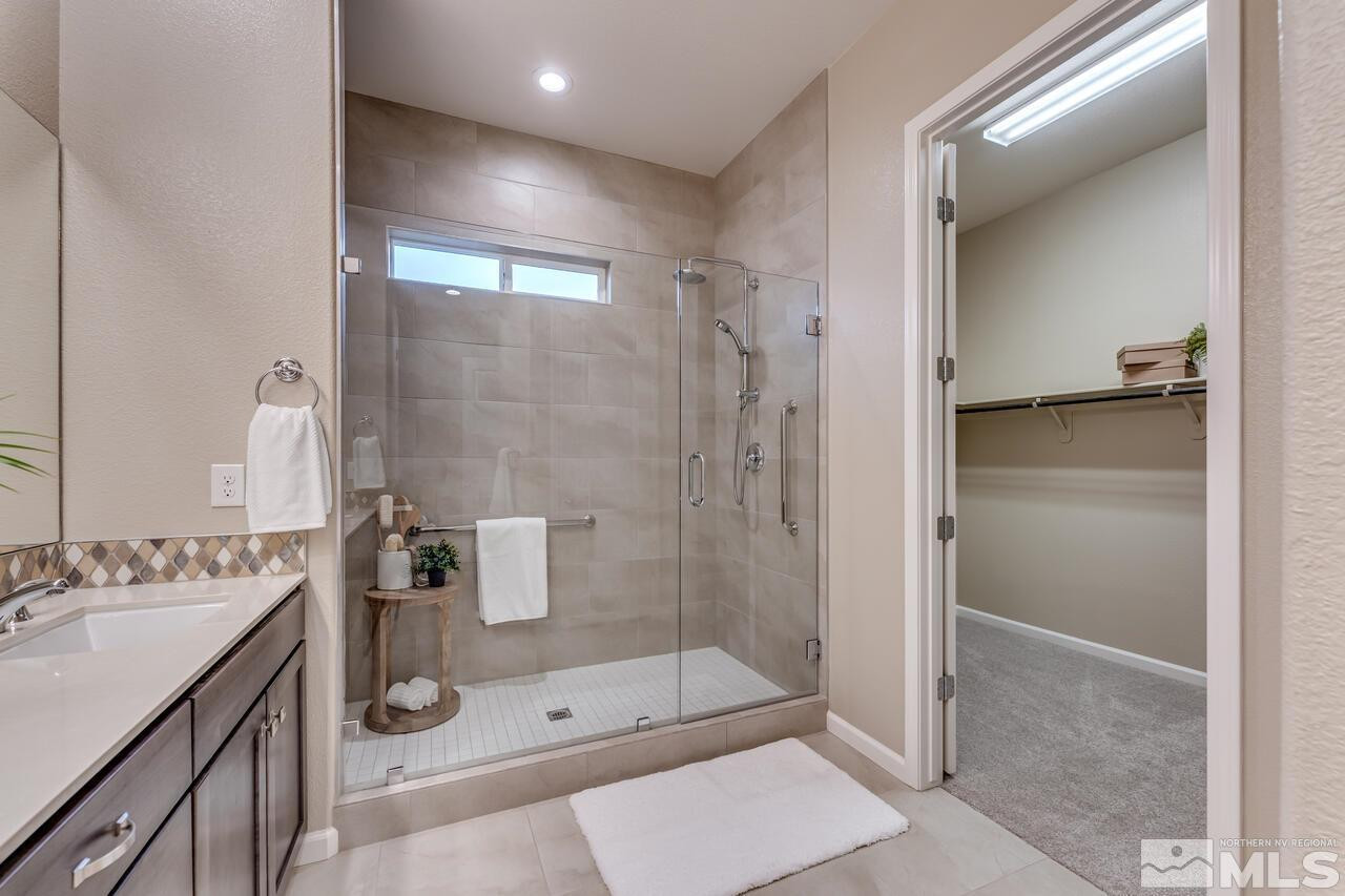 9915 Hafflinger Lane Reno, NV 89521 - Photo 24 of 40 a bathroom with a shower sink and mirror