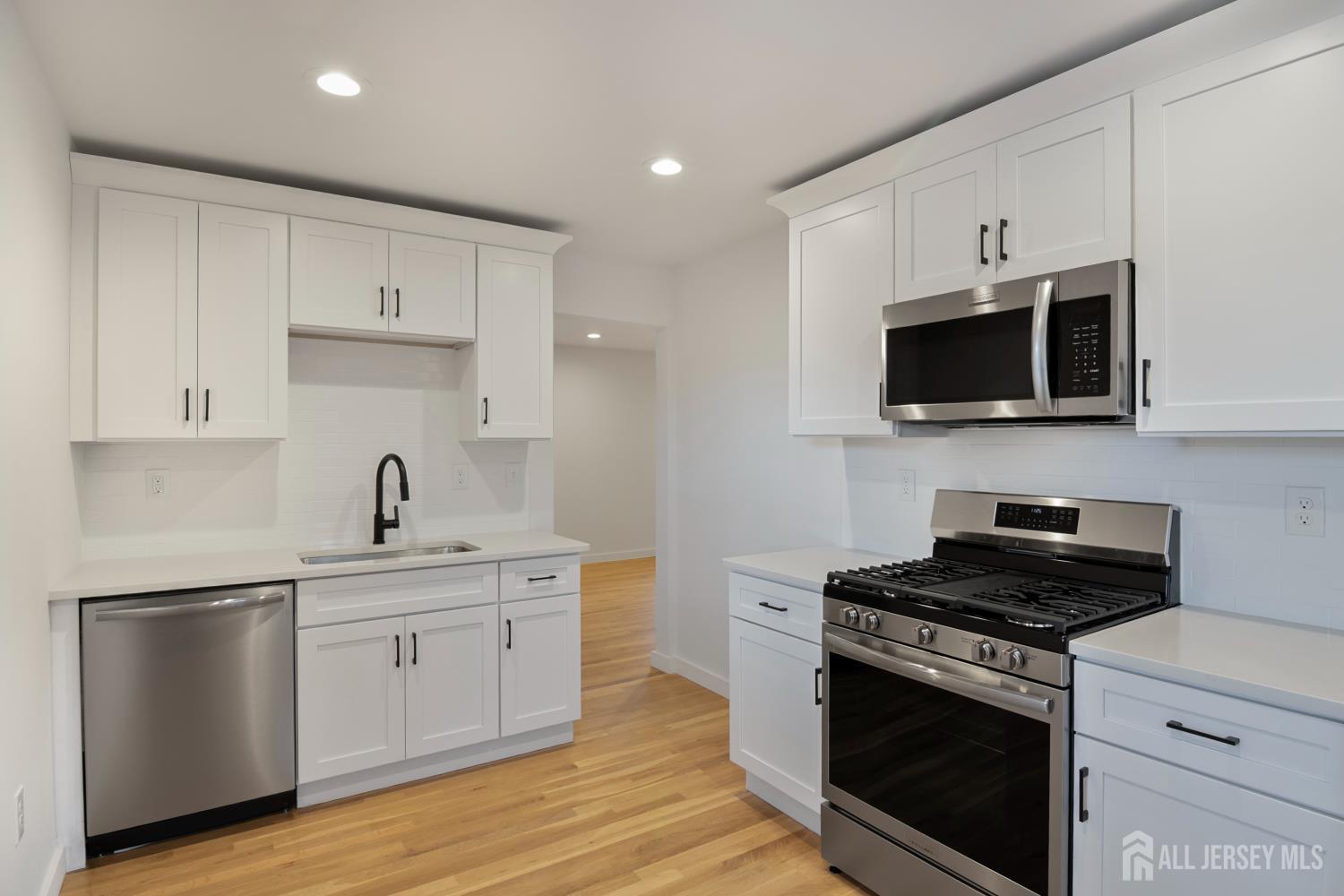 4 Morris Avenue, Unit 2A Edison, NJ 08837 - Photo 3 of 27 a kitchen with stainless steel appliances a white stove top oven and cabinets