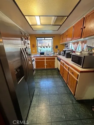 a kitchen with stainless steel appliances granite countertop a sink and refrigerator