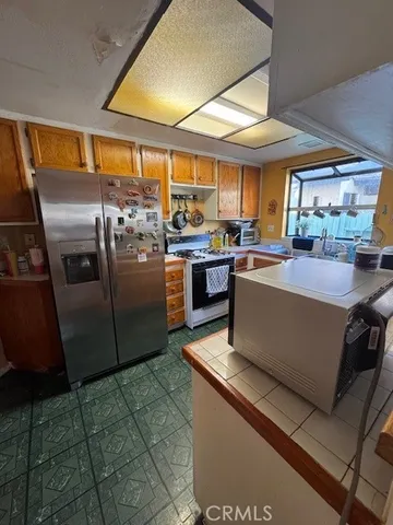 a kitchen with stainless steel appliances granite countertop a stove a sink and a refrigerator