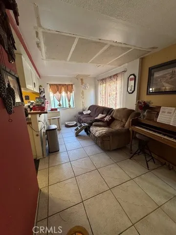 a living room with furniture a flat screen tv and a window
