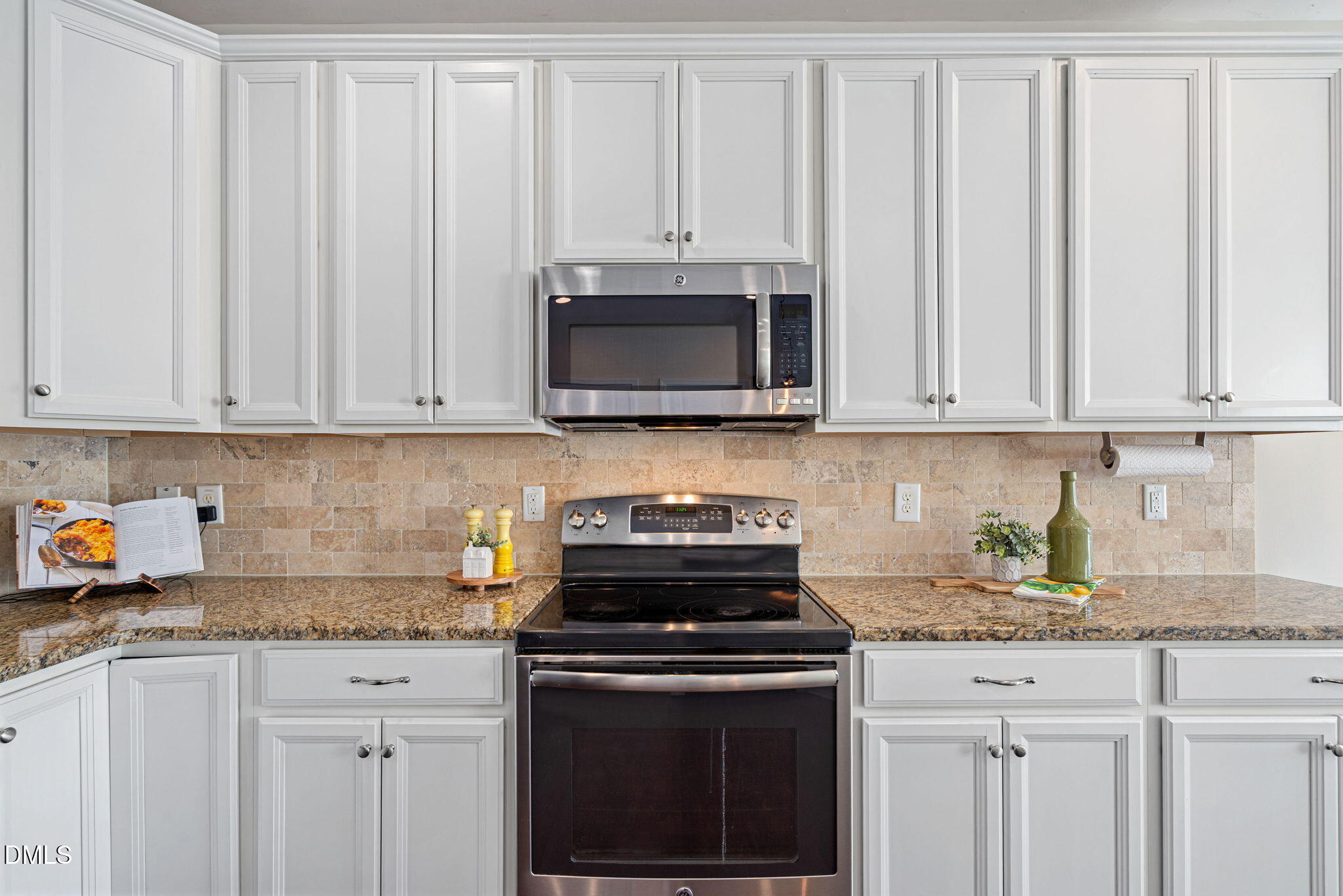 107 Ransomwood Drive Apex, NC 27539 - Photo 18 of 42 a kitchen with granite countertop white cabinets and a stove top oven
