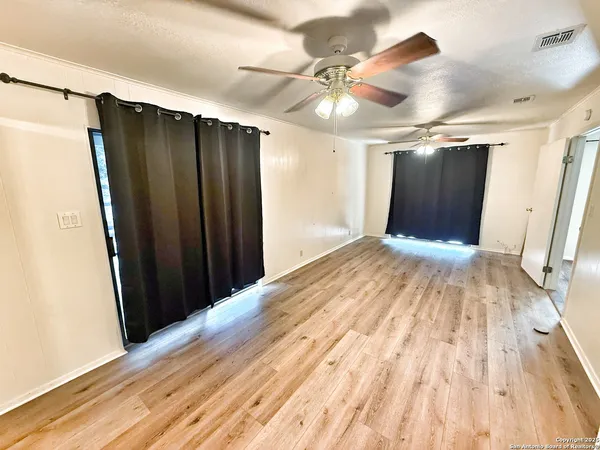 a view of empty room with wooden floor