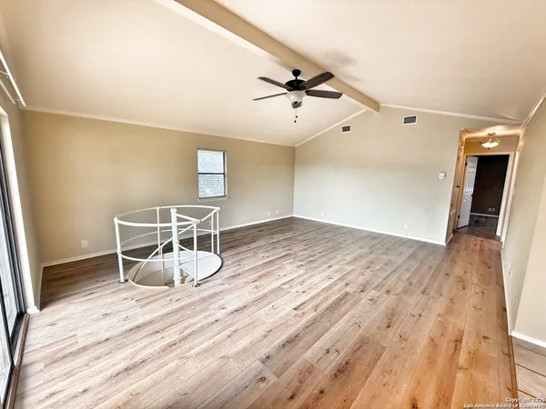 a room with wooden floor and white walls