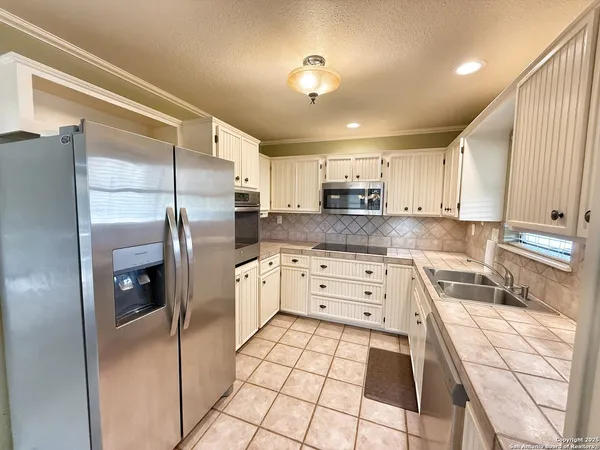 a kitchen with stainless steel appliances a refrigerator sink and cabinets