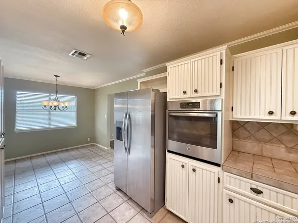 a kitchen with granite countertop a refrigerator a stove a microwave and cabinets