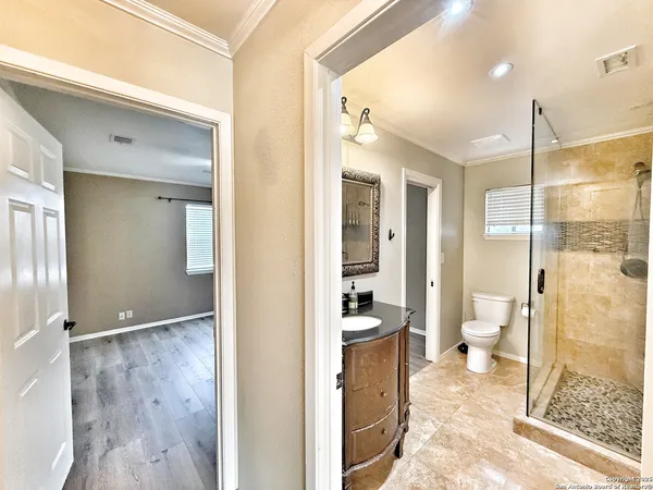 a bathroom with a glass shower door and a sink