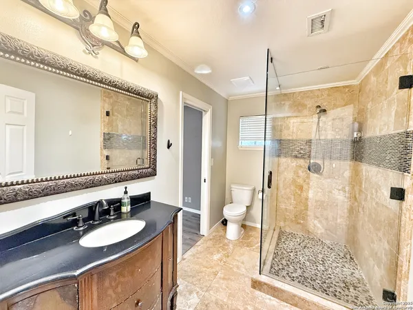 a bathroom with a double vanity sink toilet mirror and shower