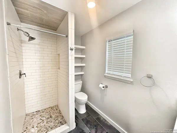 a bathroom with a toilet and a shower