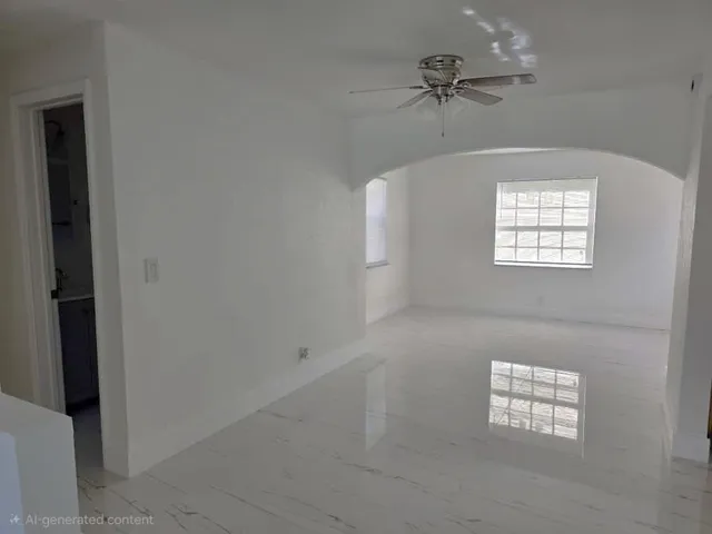 an empty room with windows and a ceiling fan