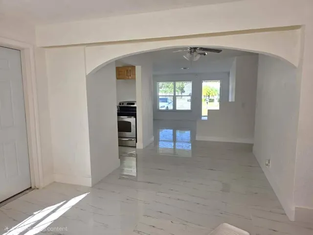 an empty room with windows and cabinet