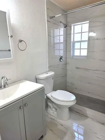 a bathroom with a toilet sink and mirror