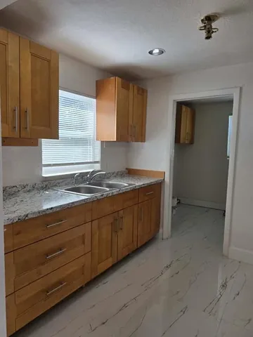 a spacious bathroom with a granite countertop sink and a mirror