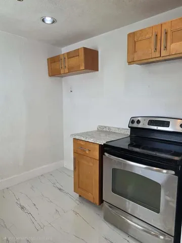 a stove top oven sitting inside of a kitchen