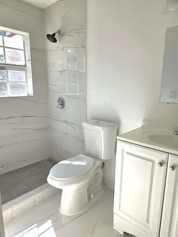 a white toilet sitting next to a bathroom sink