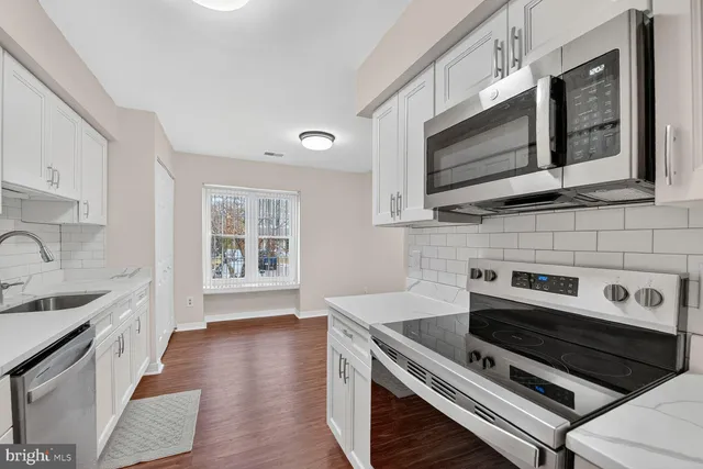 a kitchen with stainless steel appliances a stove a sink and a microwave