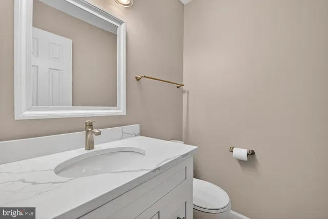 a bathroom with a sink a toilet and mirror