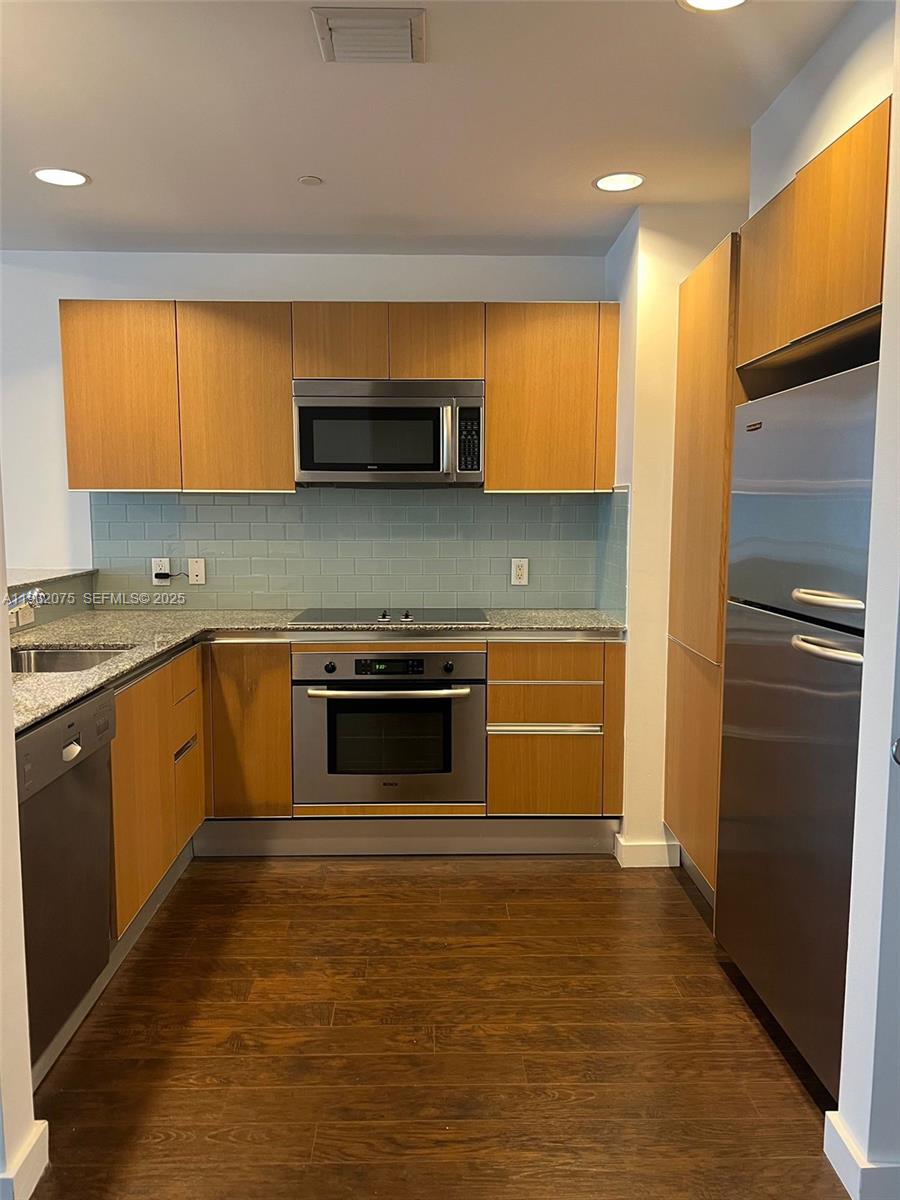 1050 Brickell Avenue, Unit 3122 Miami, FL 33131 - Photo 2 of 31 a kitchen with stainless steel appliances a stove and a refrigerator