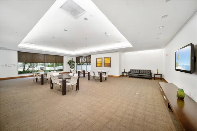 a living room with furniture pool table and windows