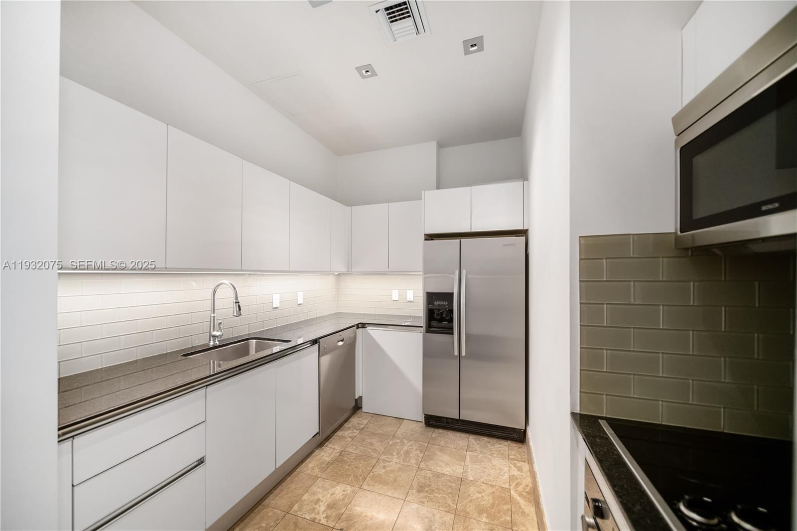 1050 Brickell Avenue, Unit 3122 Miami, FL 33131 - Photo 29 of 31 a kitchen with a sink stainless steel appliances a refrigerator and a stove