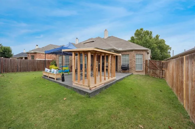a view of a chair and table in backyard of the house