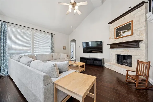 a living room with furniture a flat screen tv and a fireplace