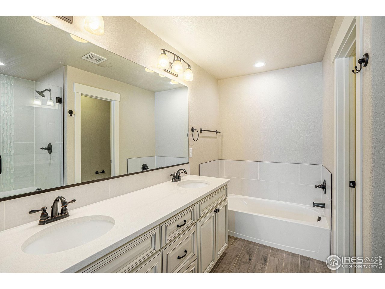 619 Davis Drive Frederick, CO 80530 - Photo 14 of 24 a bathroom with a tub sink double vanity and a mirror