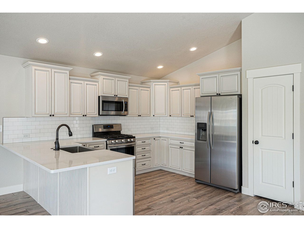 619 Davis Drive Frederick, CO 80530 - Photo 2 of 24 a kitchen with stainless steel appliances granite countertop a refrigerator and a sink