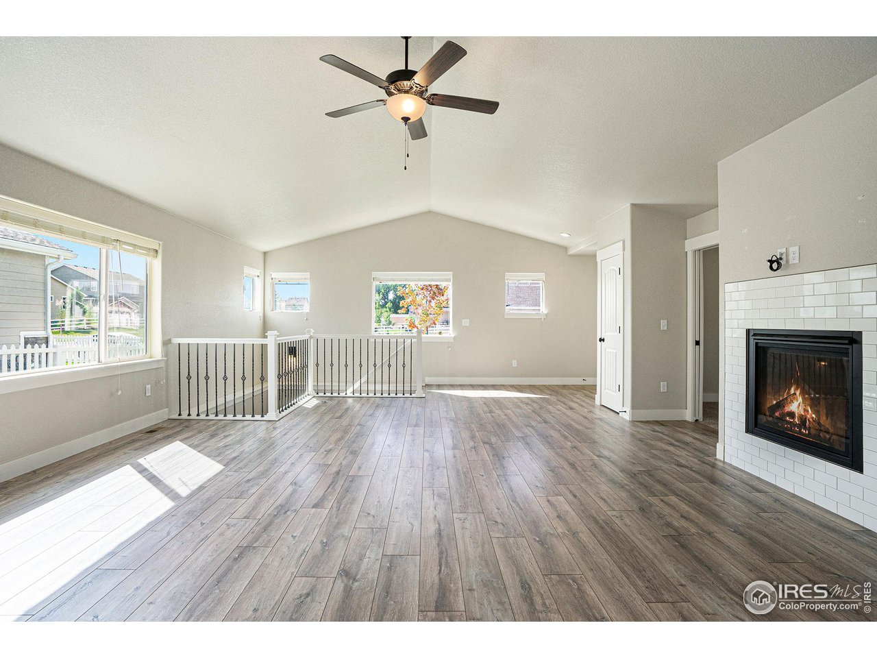 619 Davis Drive Frederick, CO 80530 - Photo 9 of 24 a view of an empty room with a window and wooden floor