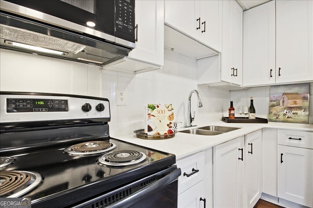 a kitchen with appliances cabinets and a stove top oven
