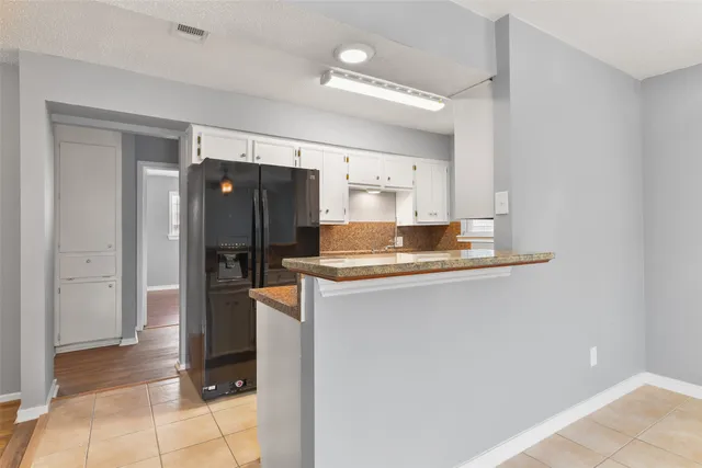 a kitchen with stainless steel appliances granite countertop a refrigerator and a stove