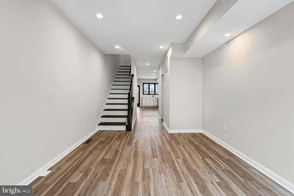 a view of a room with wooden floors and stairs
