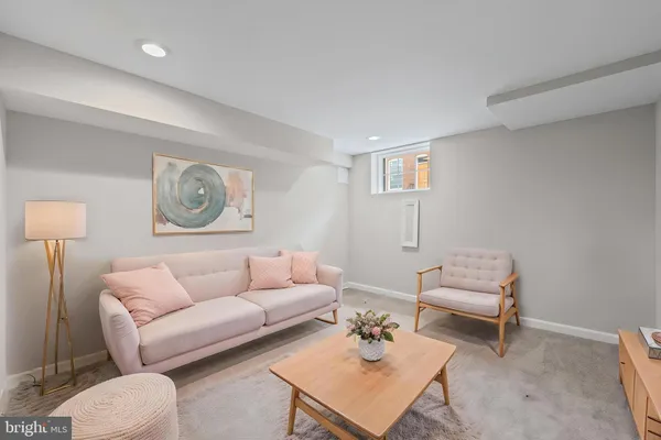 a living room with furniture and a wall painting